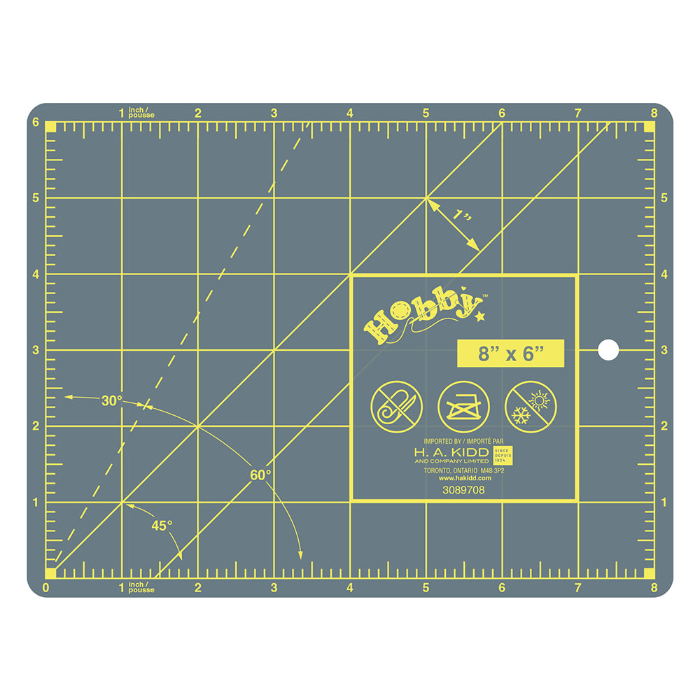 Gray cutting mat with yellow grid and measurements on a white background