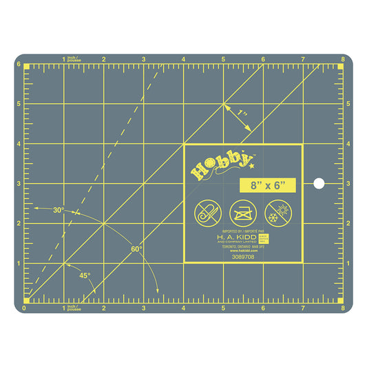 Gray cutting mat with yellow grid and measurements on a white background