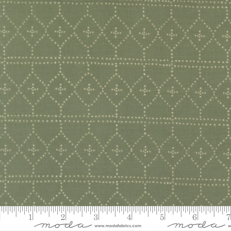 Fabric with a geometric pattern on a green background, featuring a ruler at the bottom.