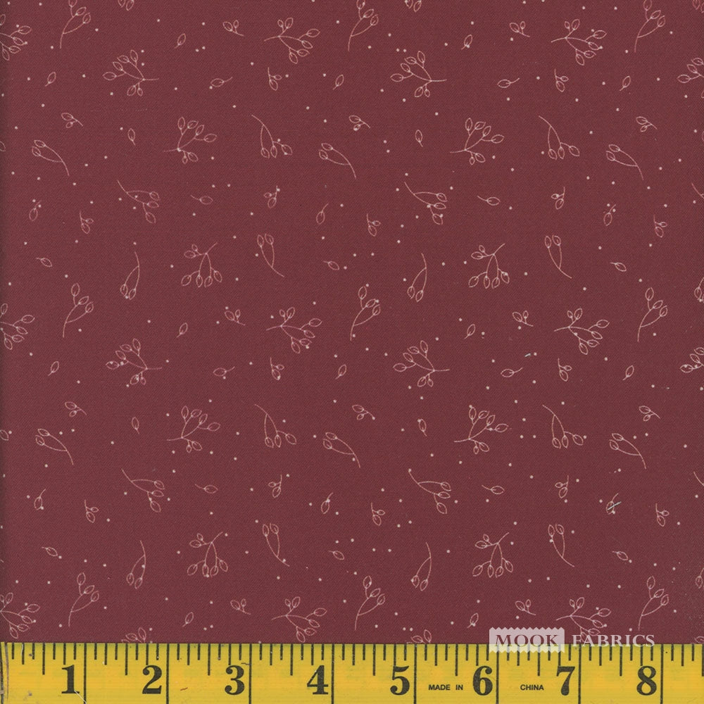 Fabric with subtle floral pattern on a red background, measured by a ruler at the bottom.