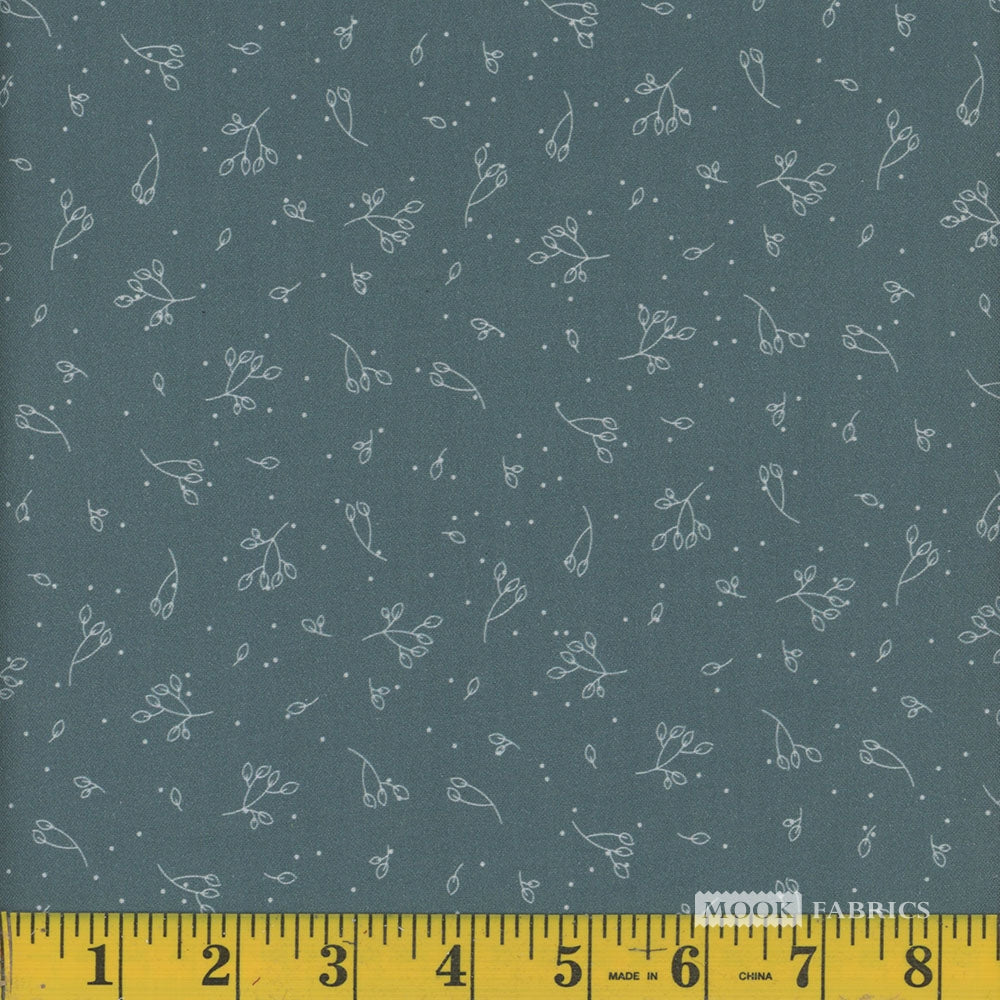 Fabric with small white floral pattern on a dark teal blue background, measured by a yellow ruler.