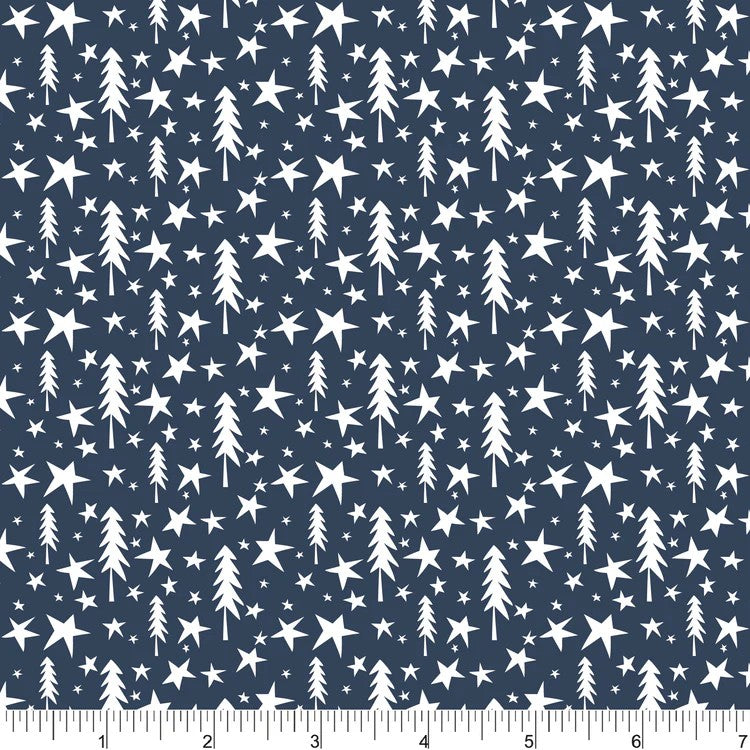 A close-up of a navy blue fabric or wallpaper pattern featuring a repeating design of white stars and stylized Christmas tree silhouettes, with a ruler at the bottom showing scale.