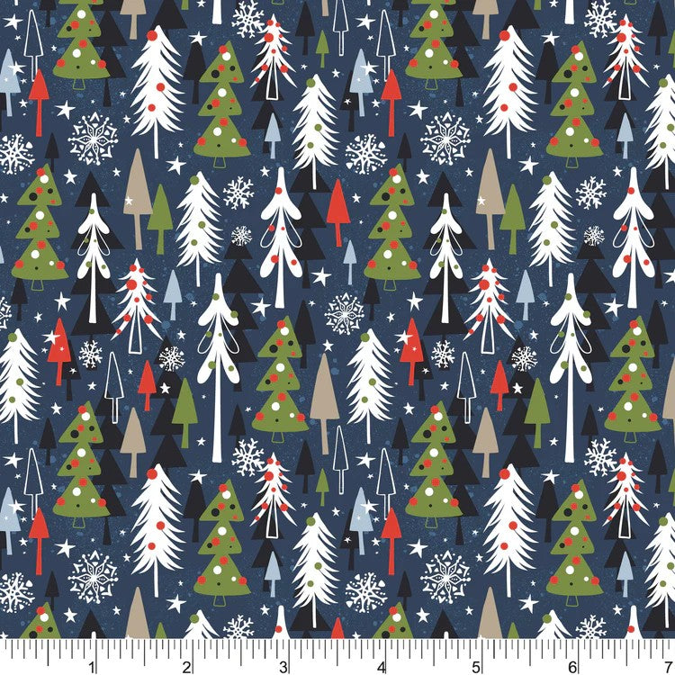 A close-up of a repeating Christmas tree pattern on fabric, with a ruler along the bottom showing the scale. The design features green, white, and red Christmas trees, pine trees, and snowflakes on a dark navy blue background.